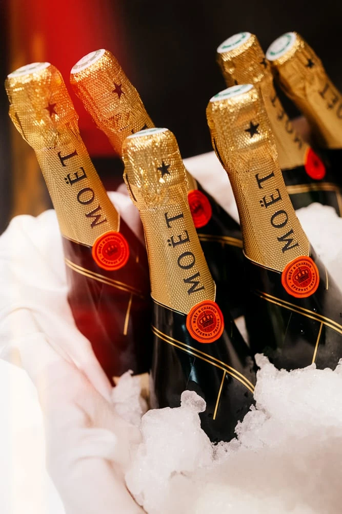 Bouteilles de champagne Moët présentées dans un seau de glace lors d'un reportage événementiel.