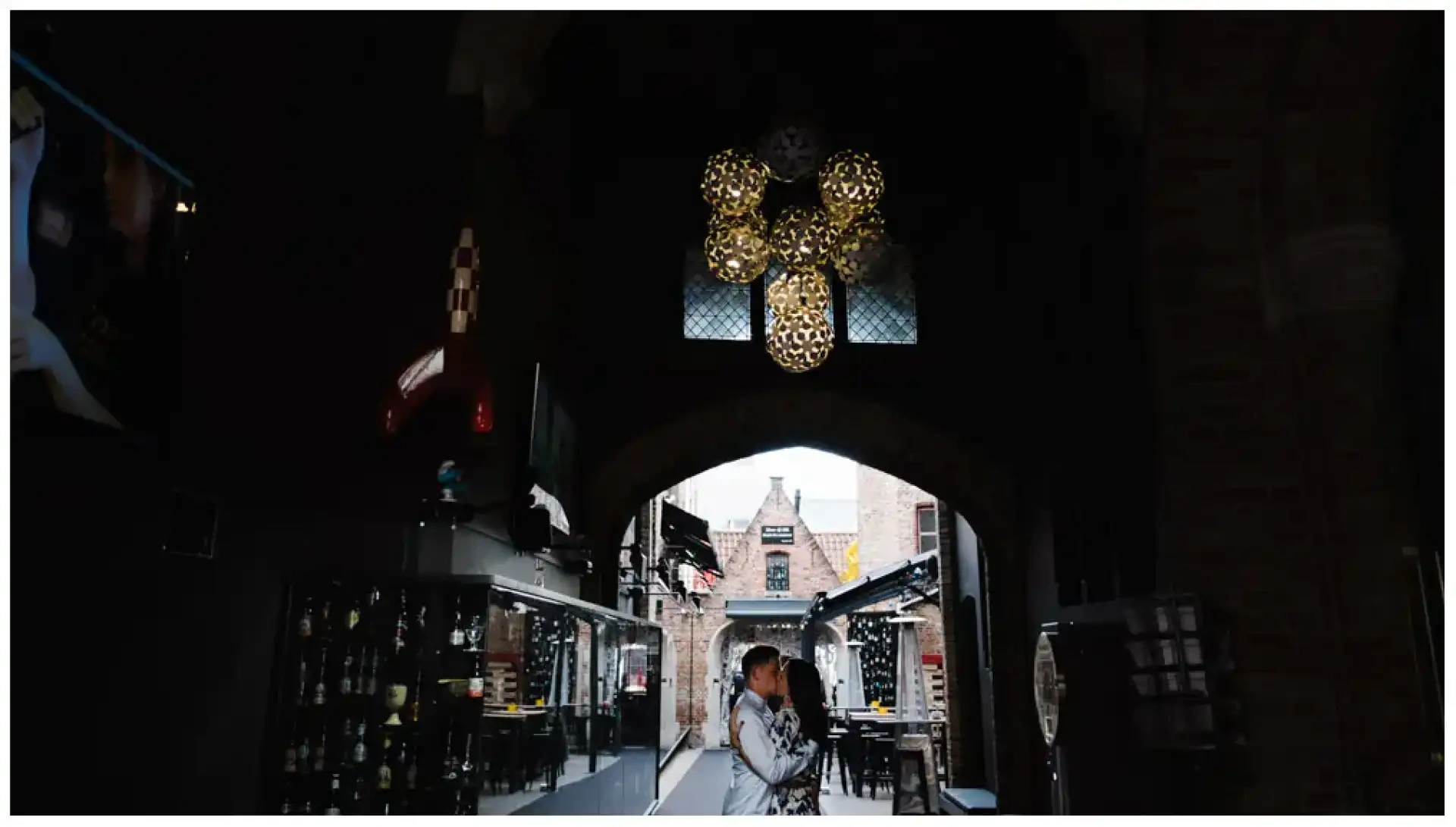 Manon et Jimmy s'embrassant sous un passage sombre ouvert sur une cour pavée.