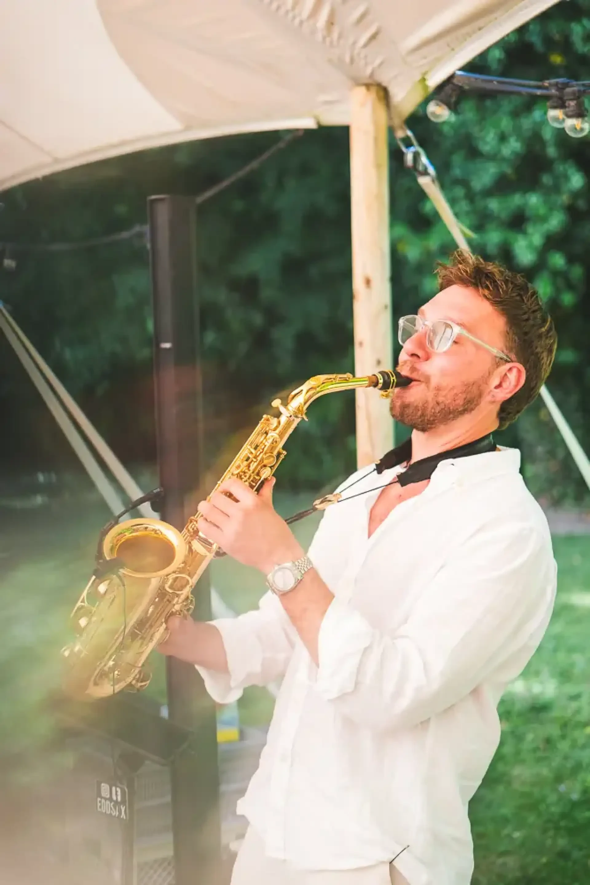 Saxophoniste jouant en plein air pendant le cocktail.