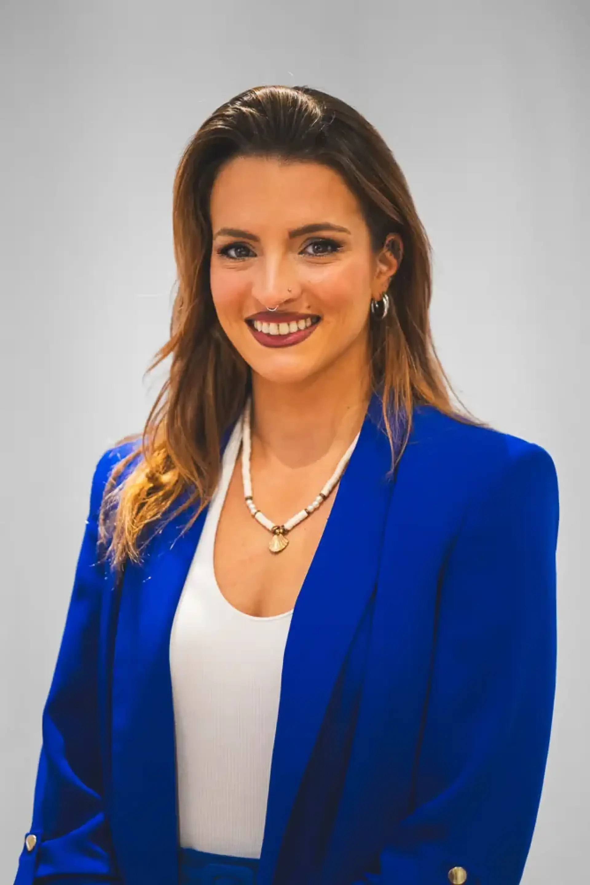 Portrait professionnel d'une femme souriante vêtue d'un tailleur bleu.