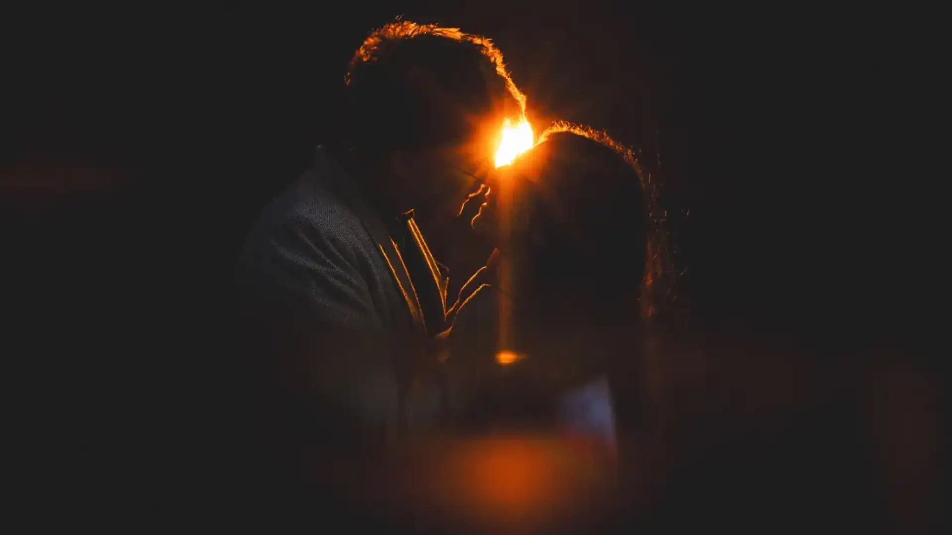 Silhouette de Victoire et Hubert s'embrassant devant le soleil couchant.